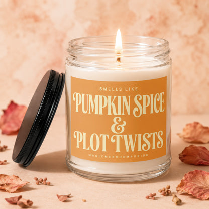 Candle "Smells Like Pumpkin Spice & Plot Twists" with lit wick.