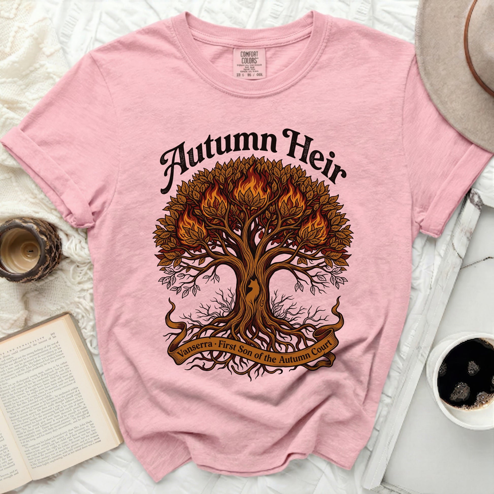 Pink t-shirt with "Autumn Heir" and a fiery tree with roots and banner.