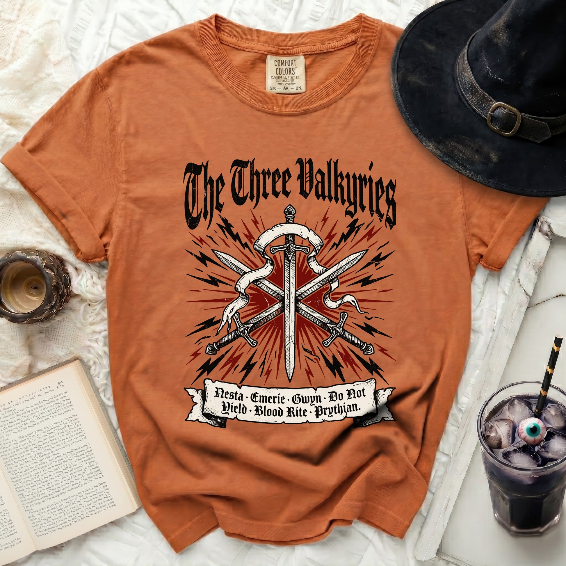 Orange t-shirt with "The Three Valkyries" and swords design.
