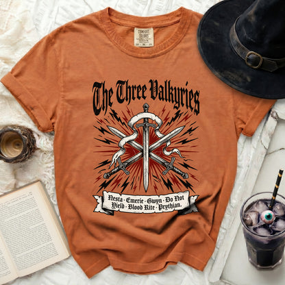 Orange t-shirt with "The Three Valkyries" and swords design.