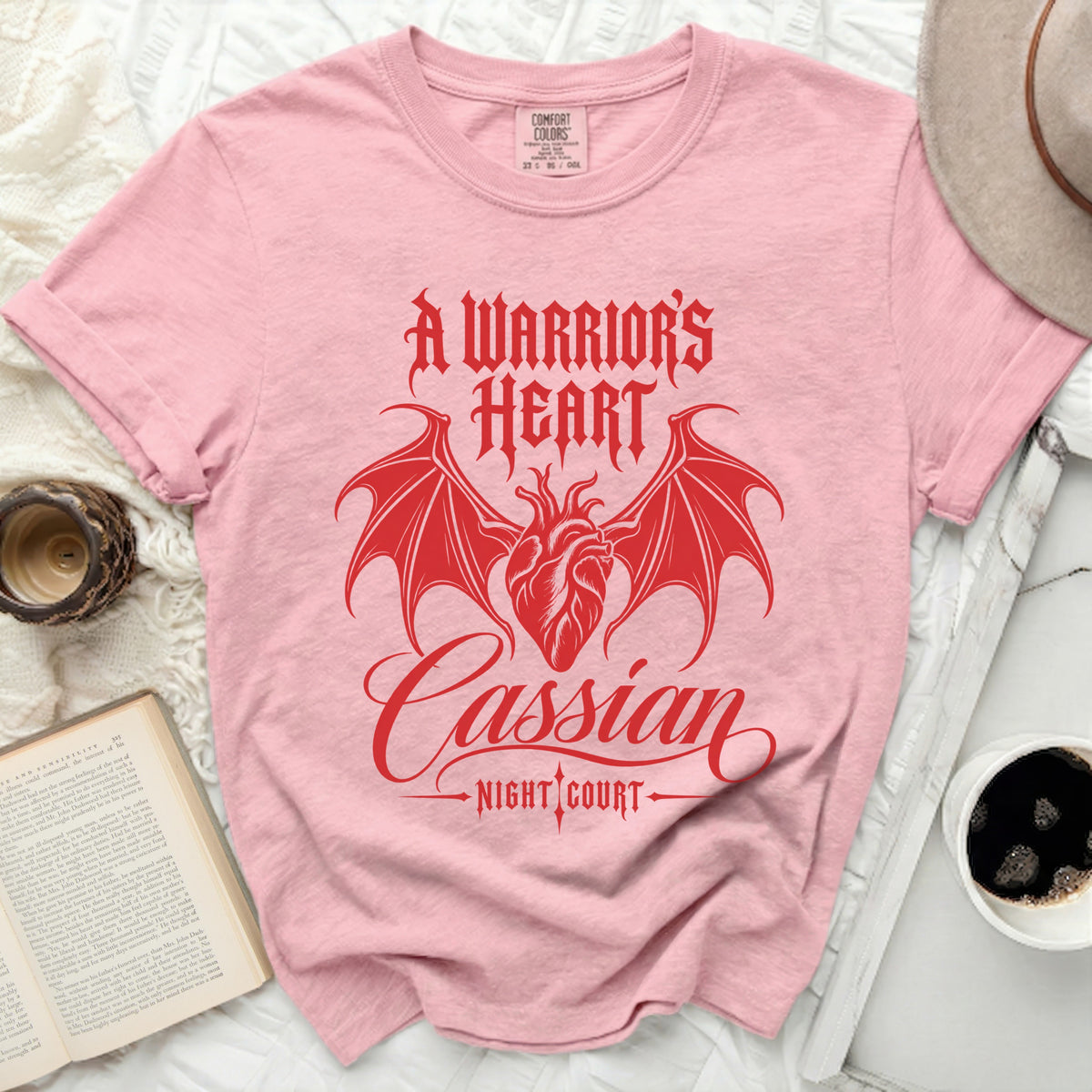 Pink t-shirt with red text and graphic of a heart with wings: A Warrior's Heart, Cassian, Night Court.