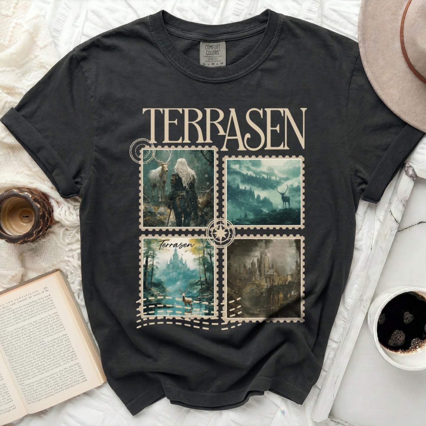 Black t-shirt with four square fantasy art prints featuring deer and misty landscapes.