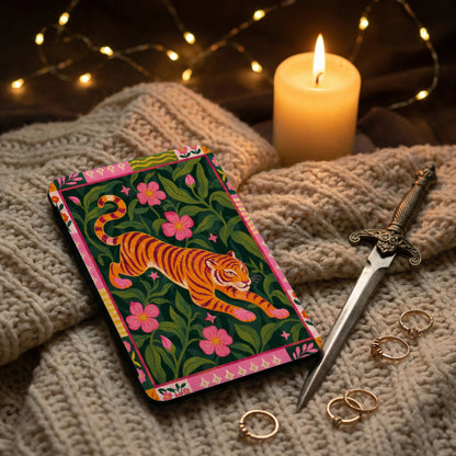 Card featuring an orange tiger on a dark green floral background, next to rings and a dagger.