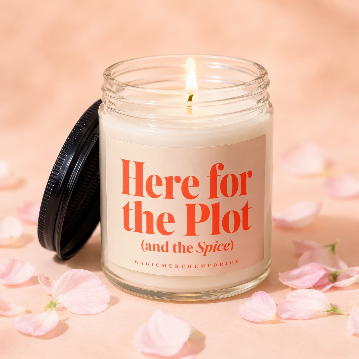 Candle with orange text "Here for the Plot (and the Spice)" surrounded by pink petals.