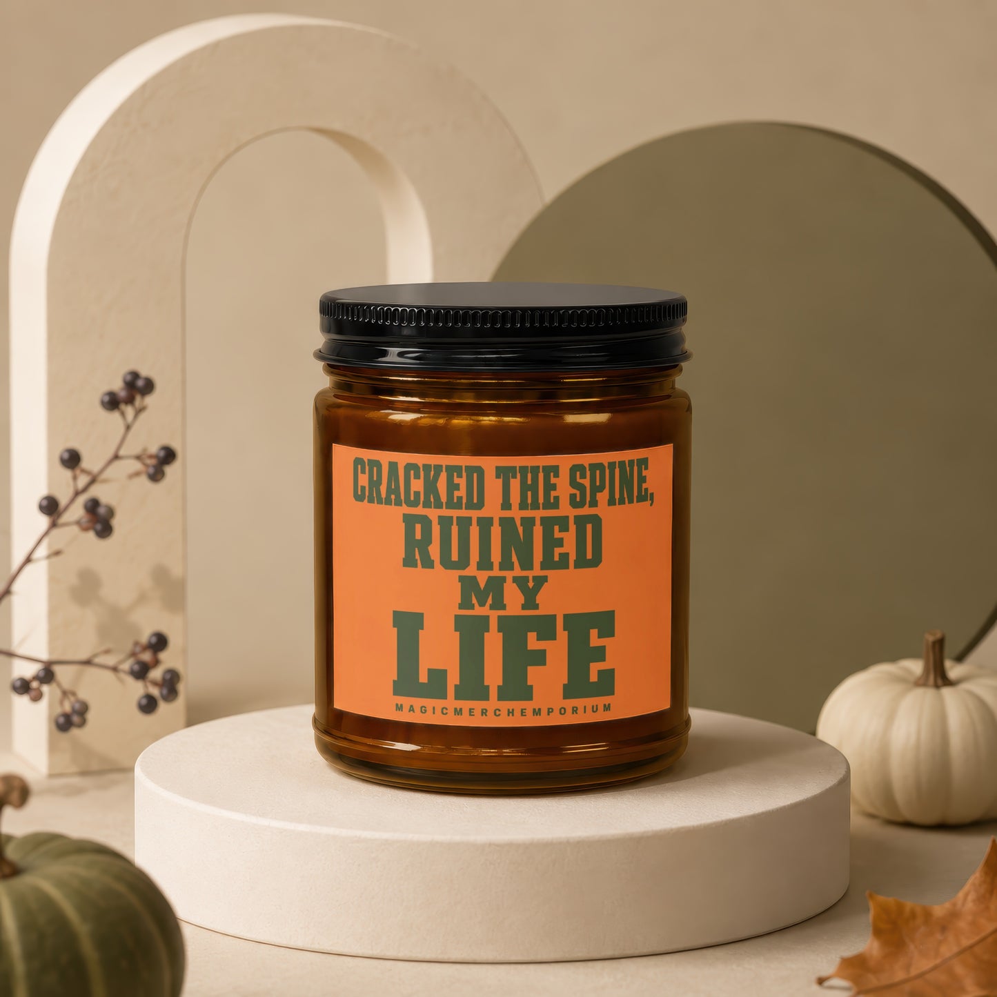 Candle with "CRACKED THE SPINE, RUINED MY LIFE" text on orange label.