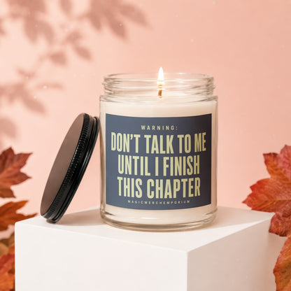 Lit candle in glass jar with label: "WARNING: DON'T TALK TO ME UNTIL I FINISH THIS CHAPTER"