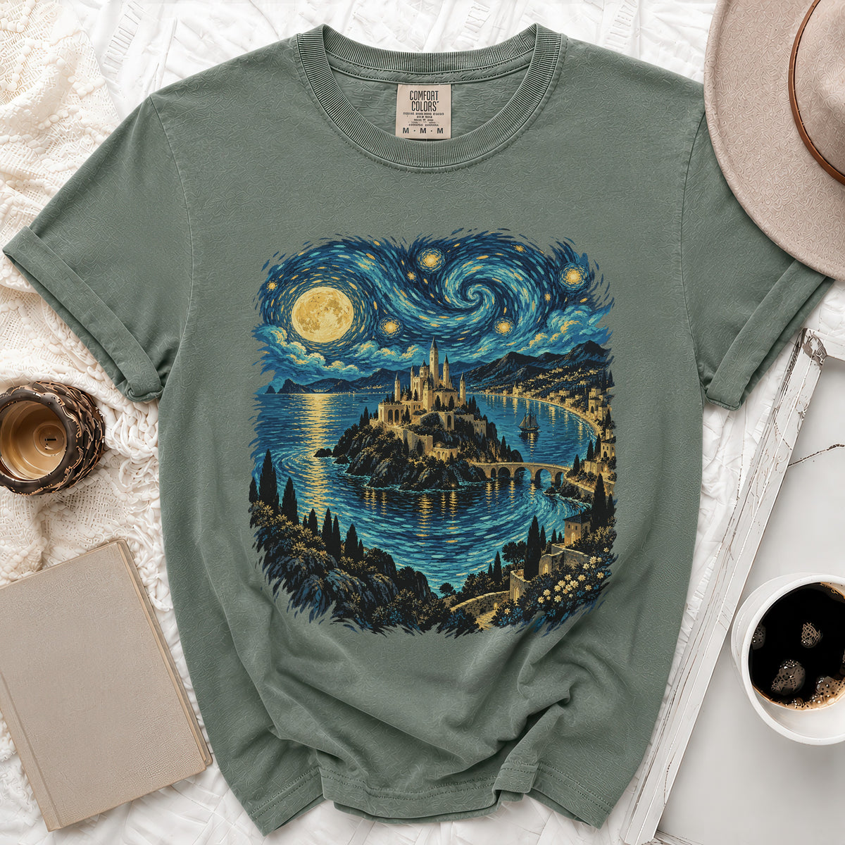 Green t-shirt with a castle by the sea under a swirling starry sky.