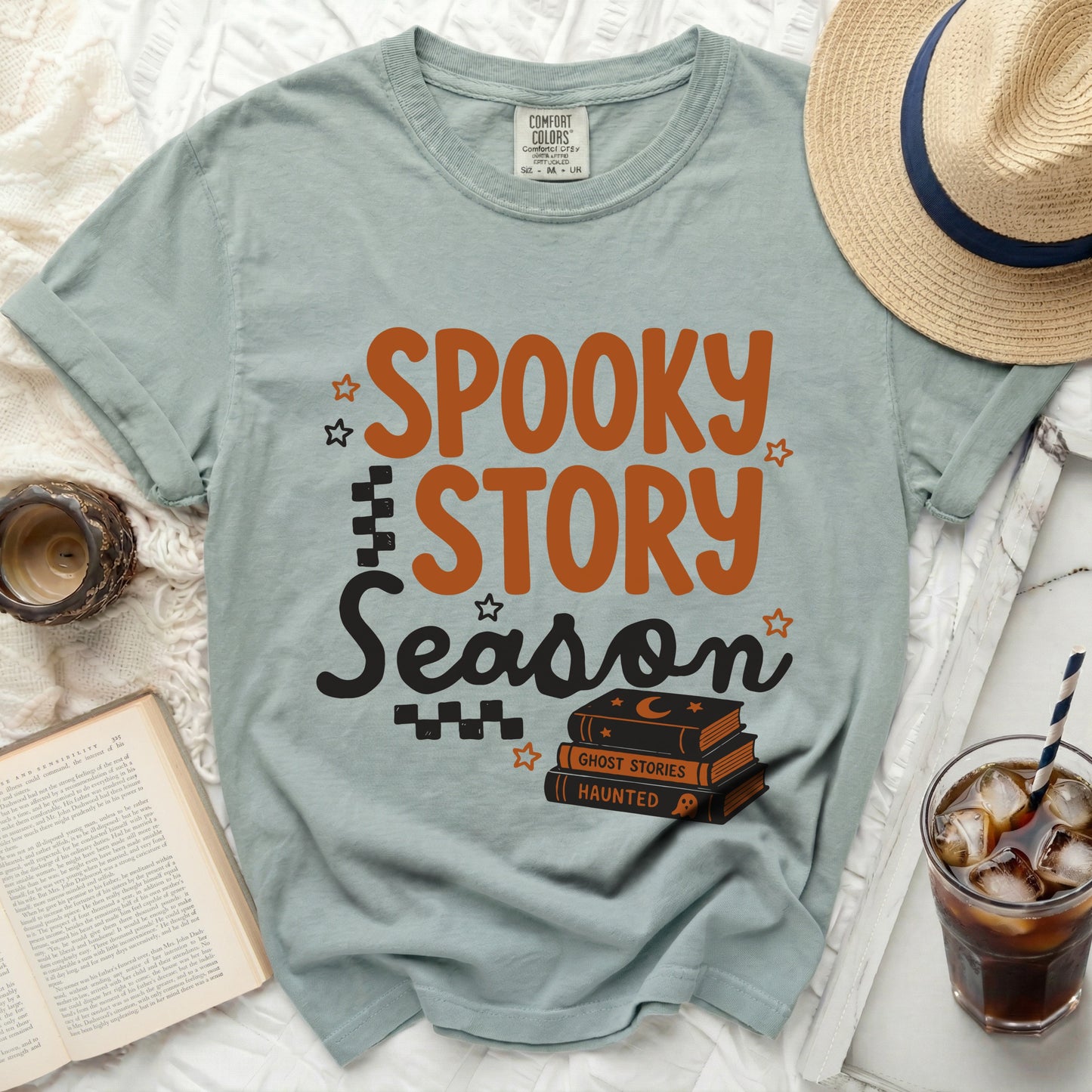 Green t-shirt with "Spooky Story Season" text and stacked books.