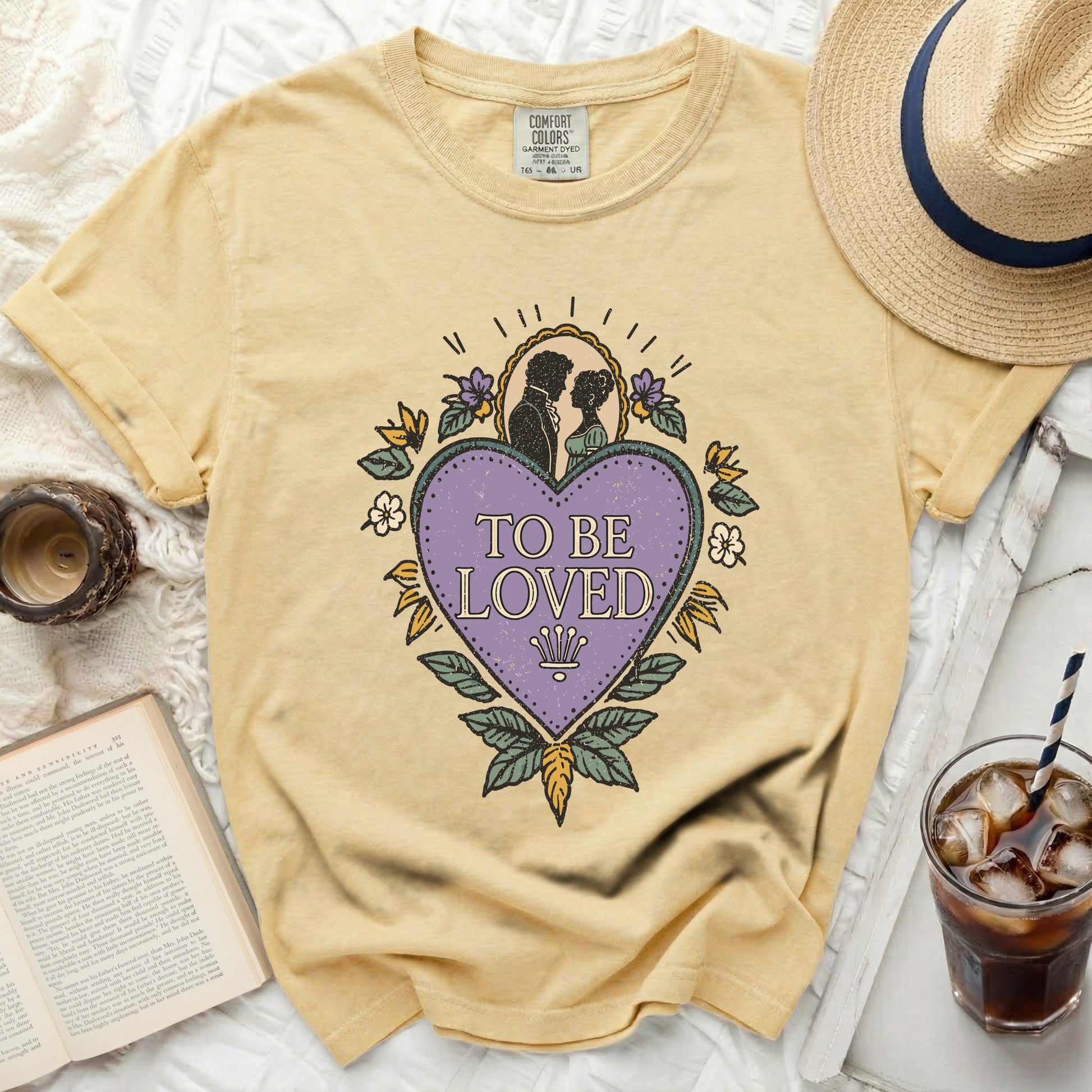 Yellow t-shirt with "To Be Loved" graphic and romantic couple silhouette