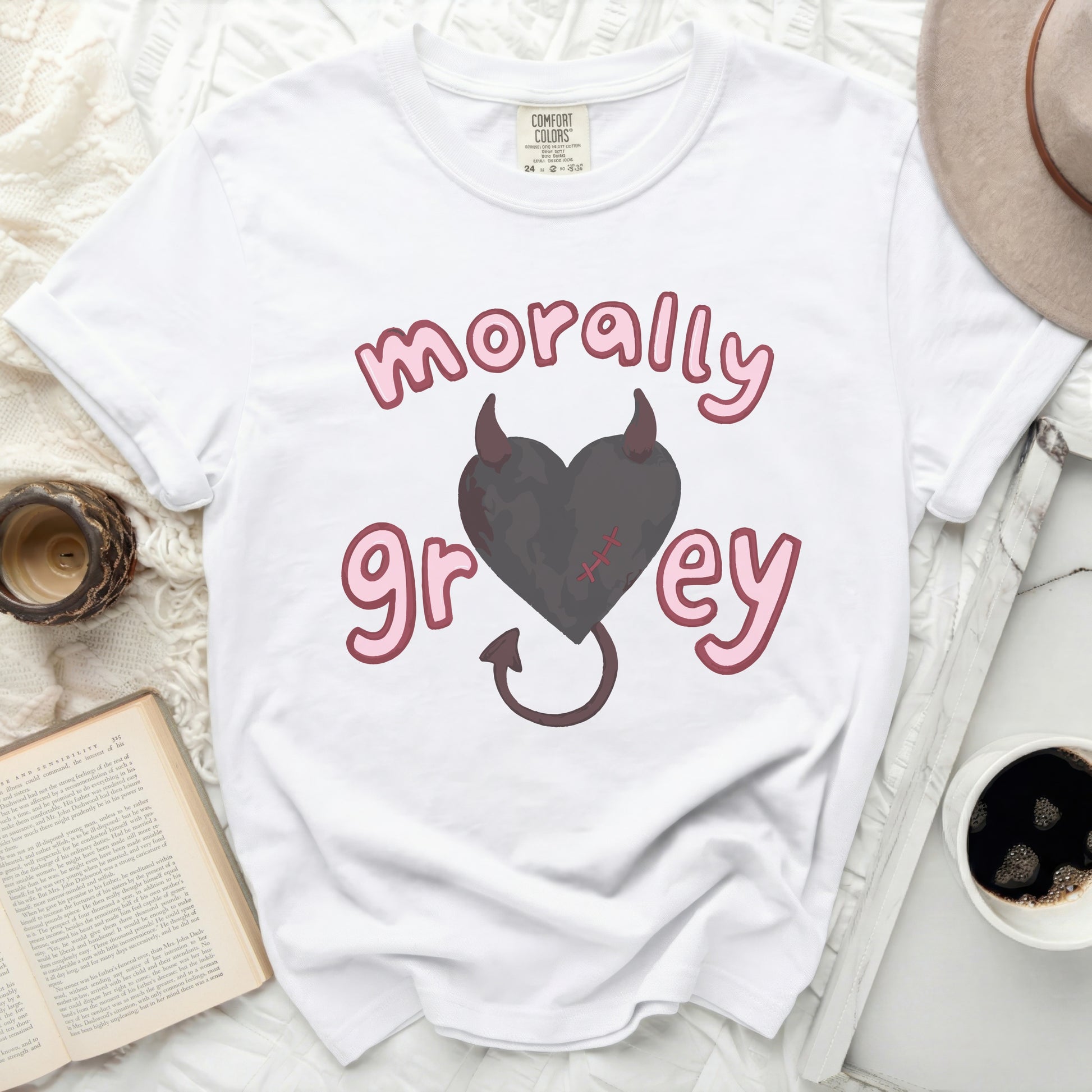 White t-shirt with pink text "morally grey" and a grey heart with devil horns.