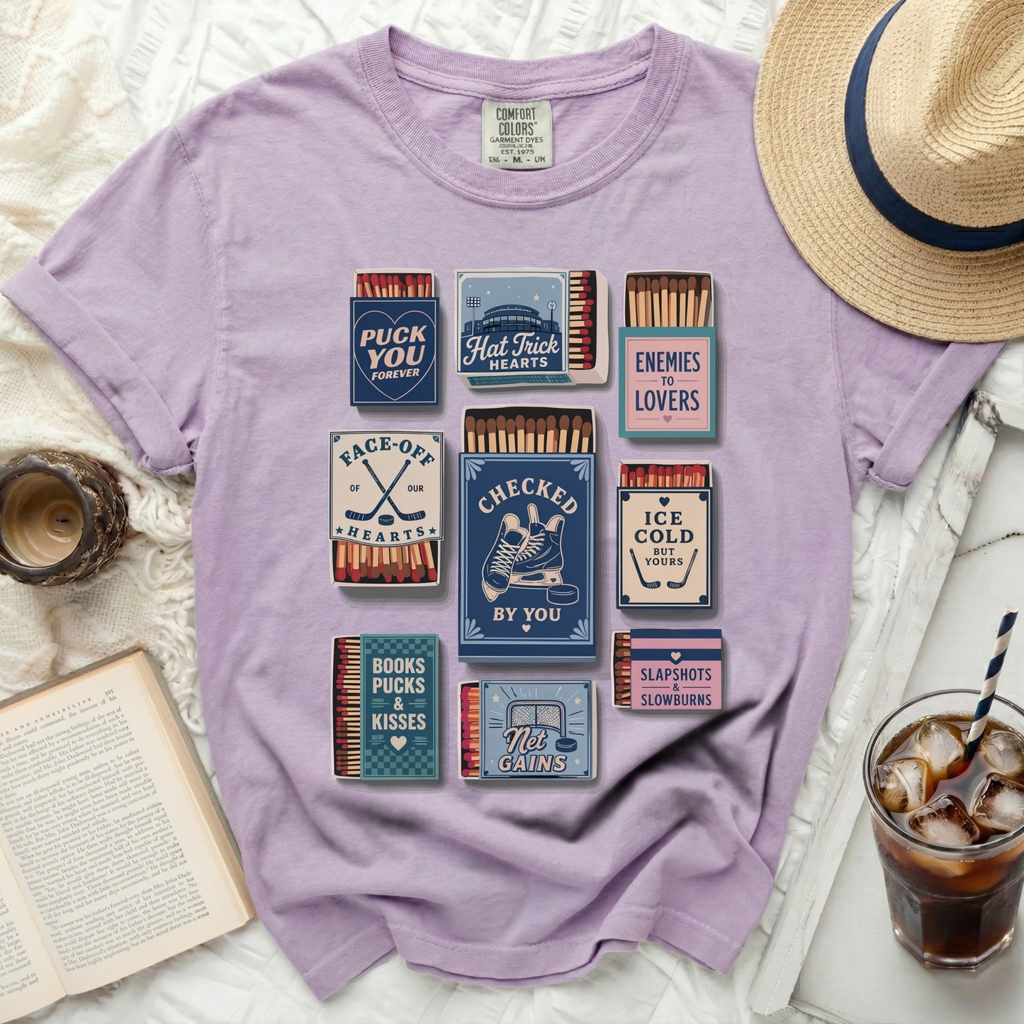 Purple t-shirt with vintage hockey-themed graphics including matchboxes and text.