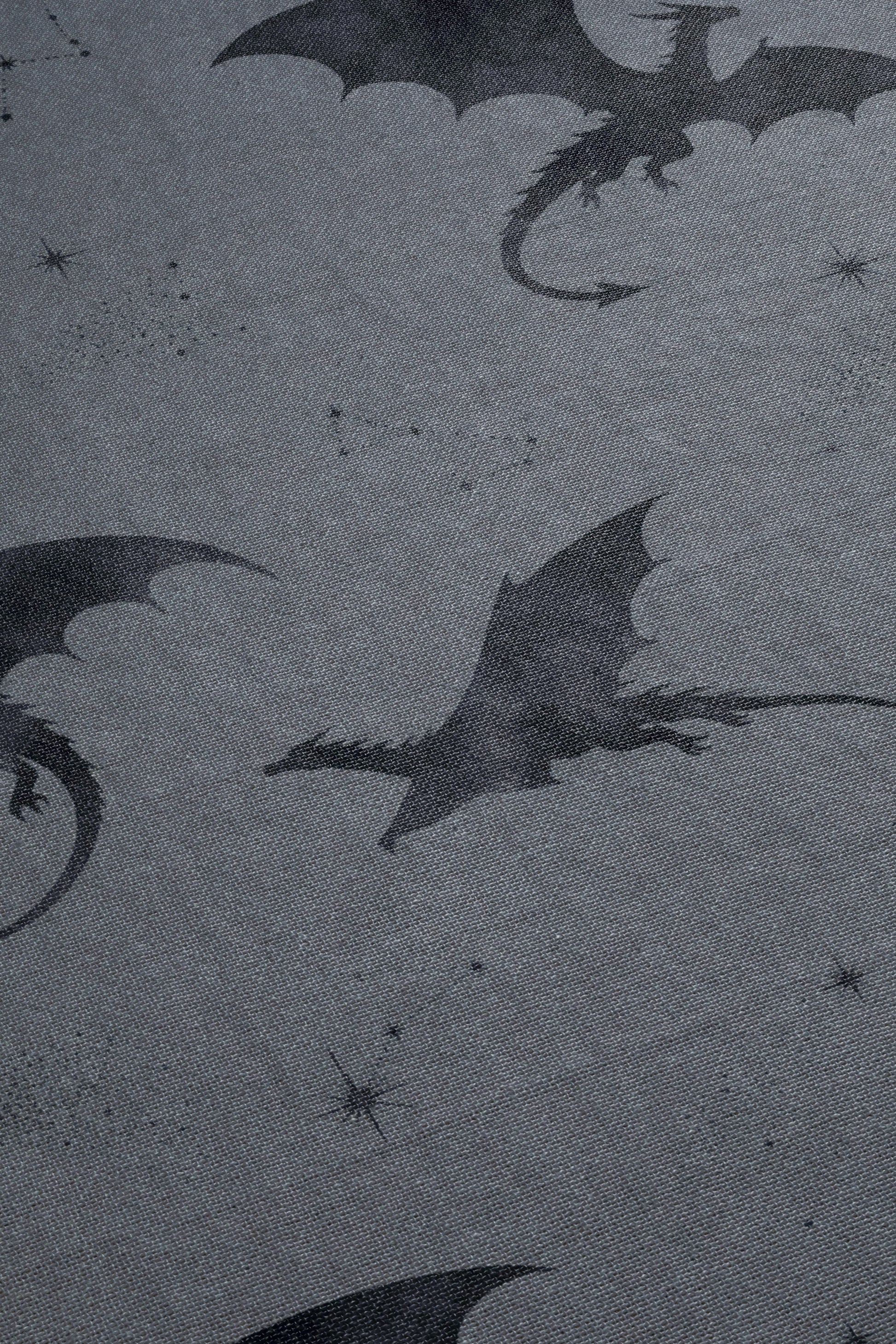 a dark, moody scene with silhouettes of dragons and stars against a dark background.