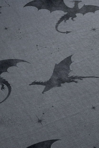 a dark, moody scene with silhouettes of dragons and stars against a dark background.