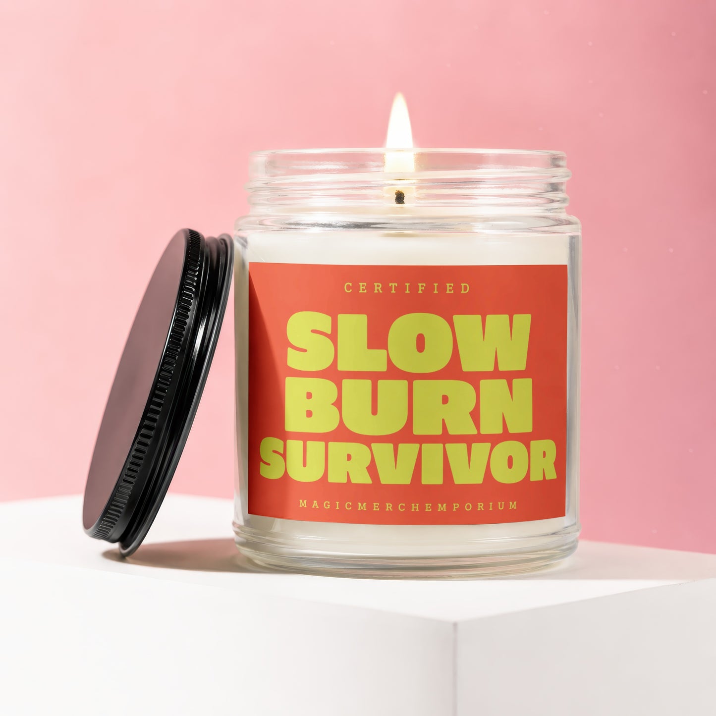 Candle with "Slow Burn Survivor" in yellow text on a red label.