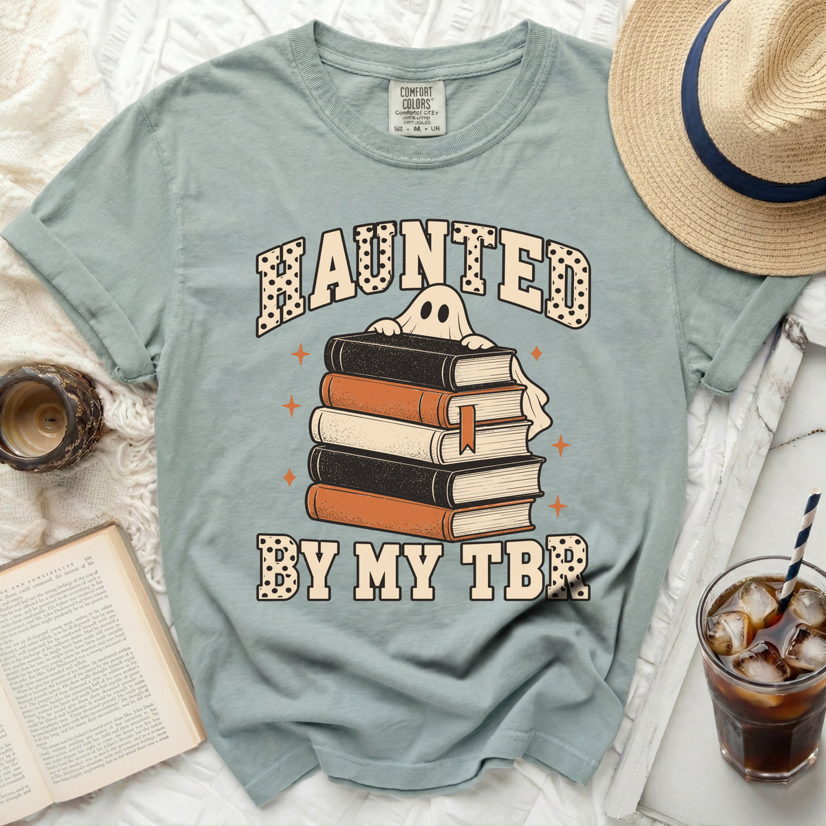 Light blue t-shirt with "Haunted By My TBR." and a ghost holding books.