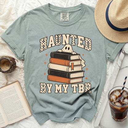 Light blue t-shirt with "Haunted By My TBR." and a ghost holding books.