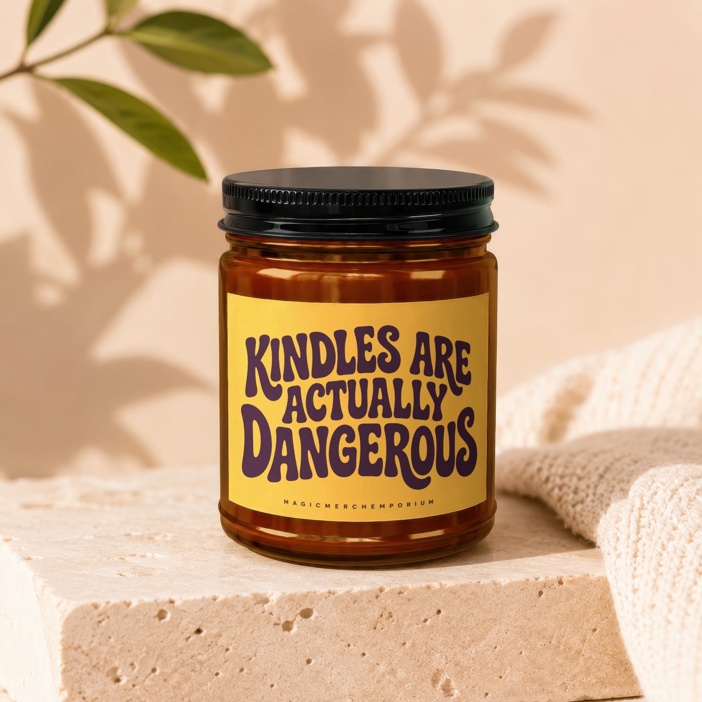 Amber jar candle with a yellow label that reads "Kindles are actually dangerous".
