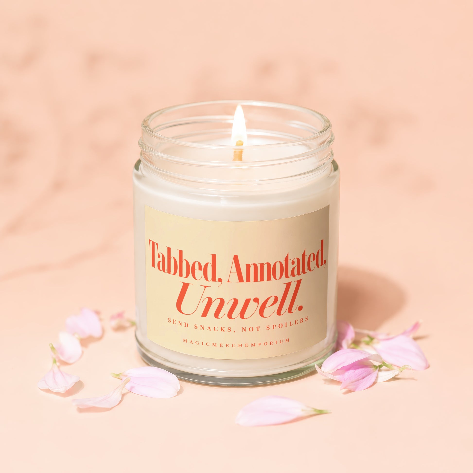 Glass candle with text "Tabbed, Annotated. Unwell. Send snacks, not spoilers."