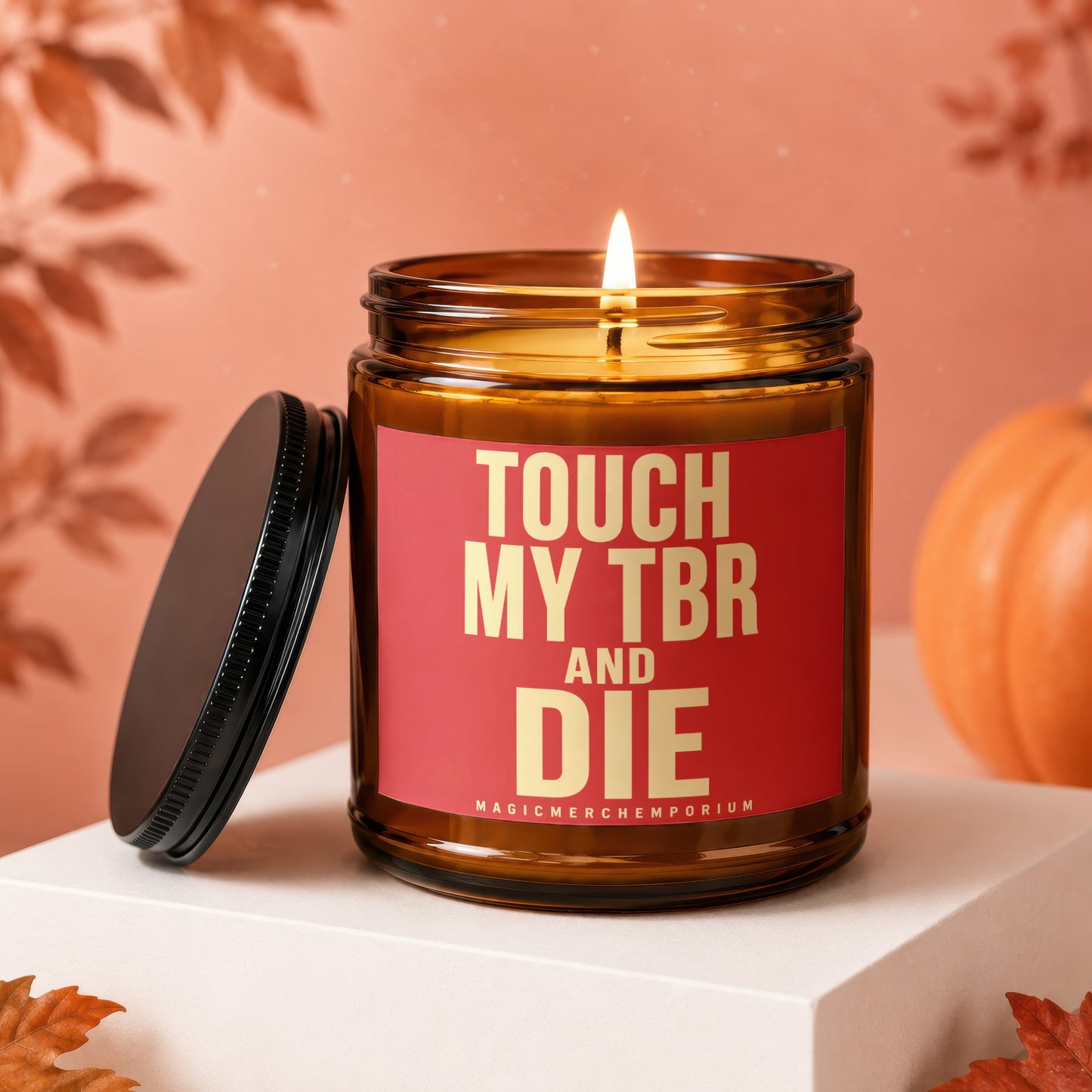 Amber jar candle with lit wick and red label reading "TOUCH MY TBR AND DIE".