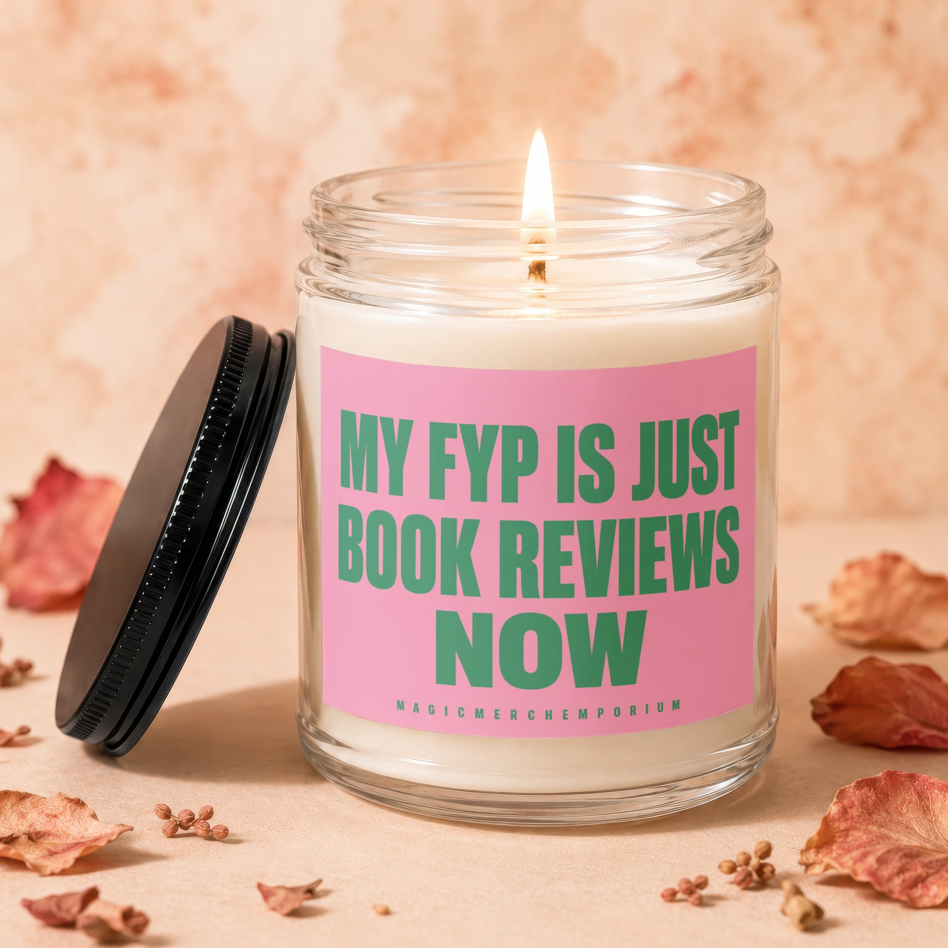 Lit candle in glass jar with pink label reading "MY FYP IS JUST BOOK REVIEWS NOW".