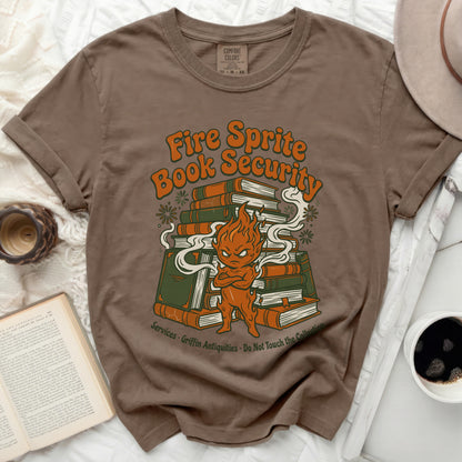 Brown t-shirt with a cartoon fire sprite and pile of books graphic.