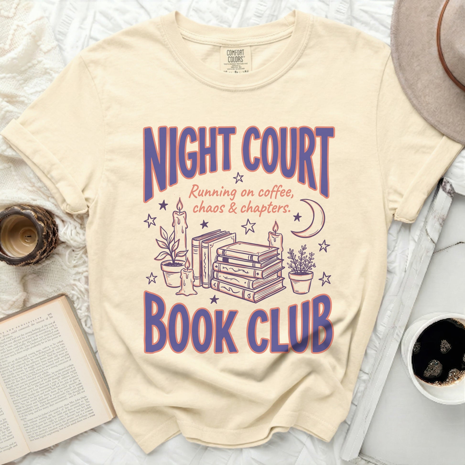 Cream t-shirt with purple "NIGHT COURT BOOK CLUB" text and illustrations.
