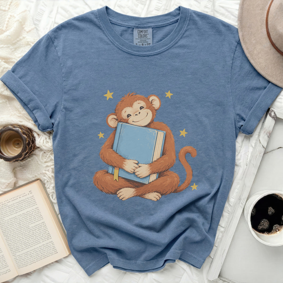 Blue t-shirt with a cartoon monkey hugging a blue book.