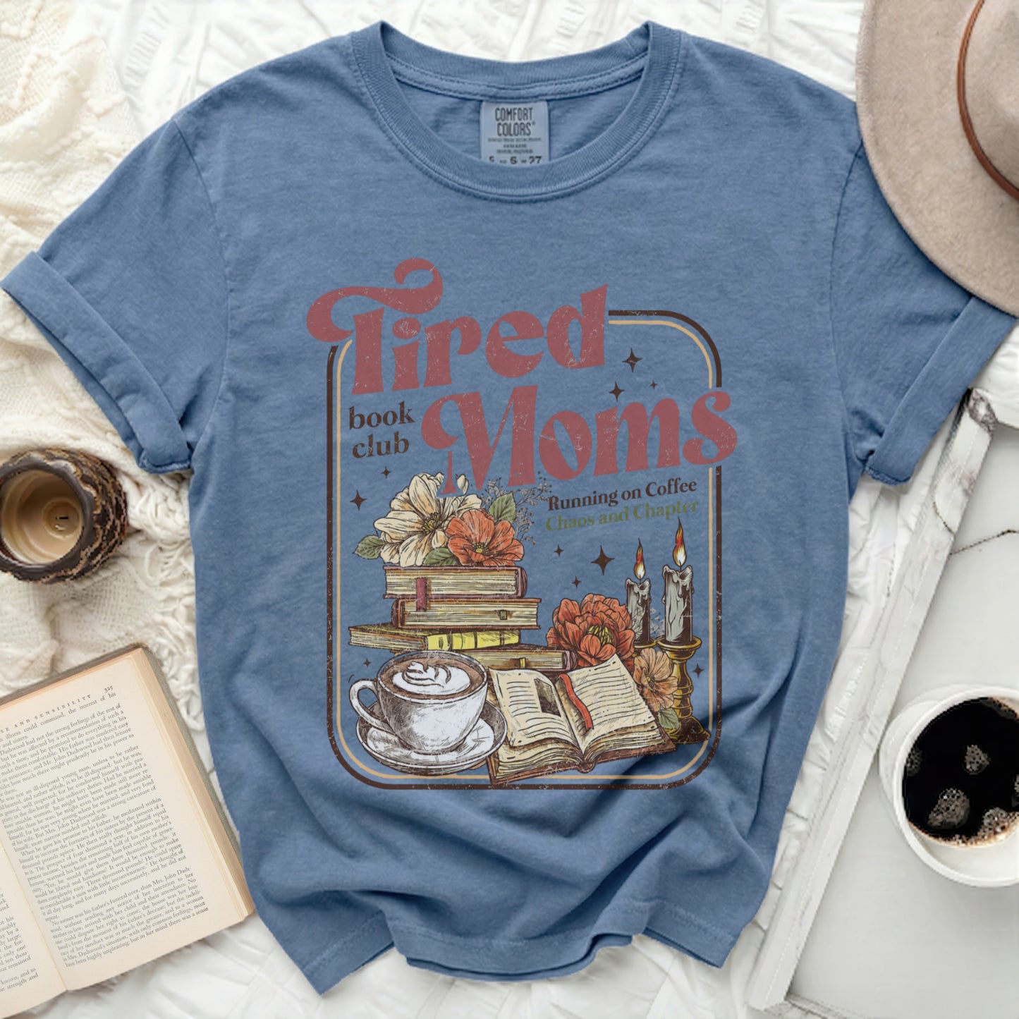 Blue t-shirt with "Tired Moms Book Club" graphic featuring coffee and books.