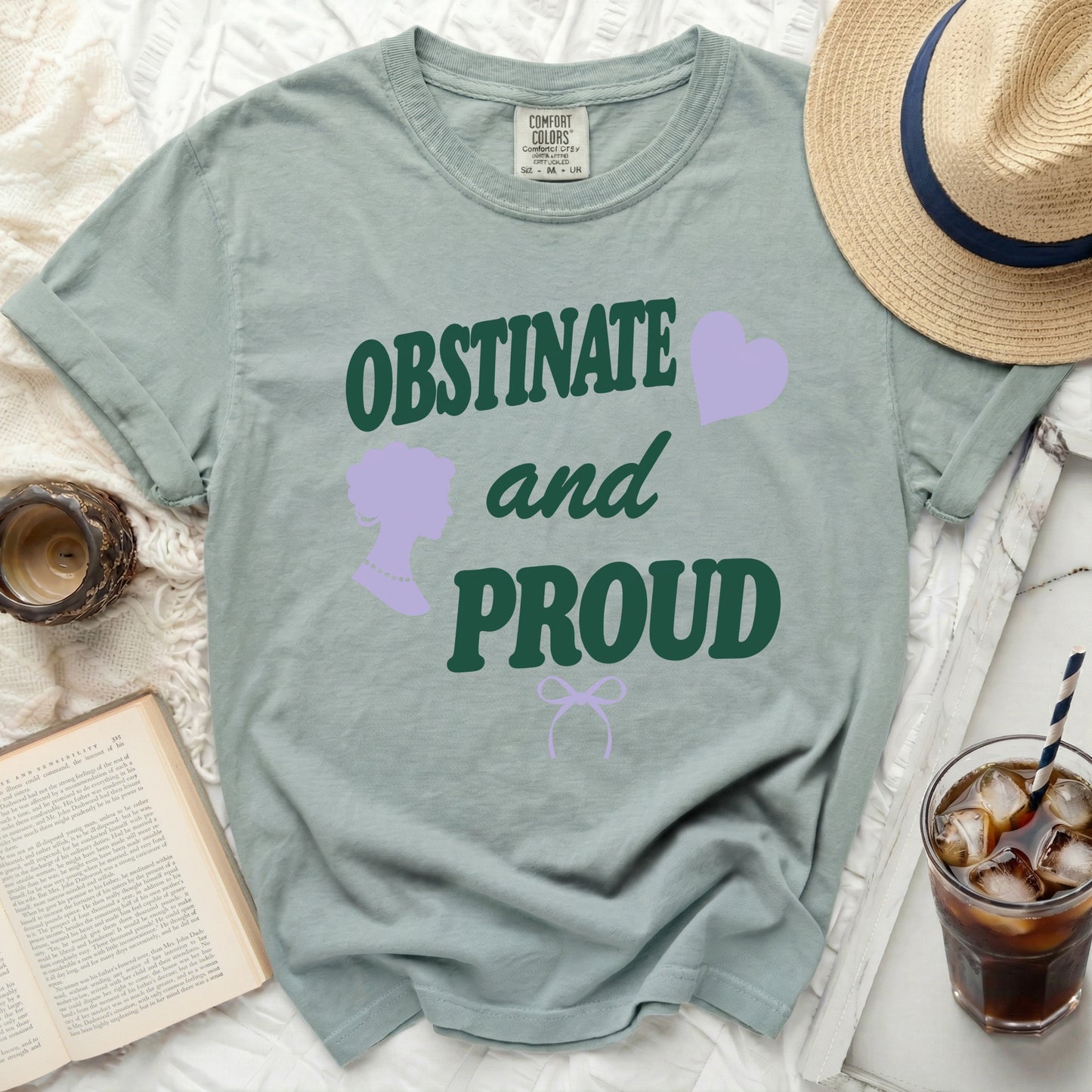 Green t-shirt with "OBSTINATE and PROUD" text and lavender accents.
