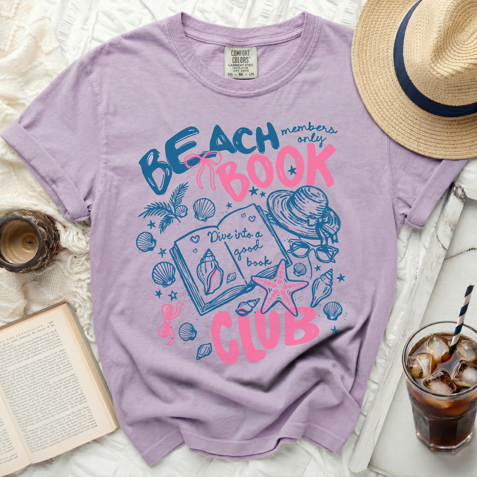 Purple t-shirt with "Beach Book Club" graphic featuring shells and a book.