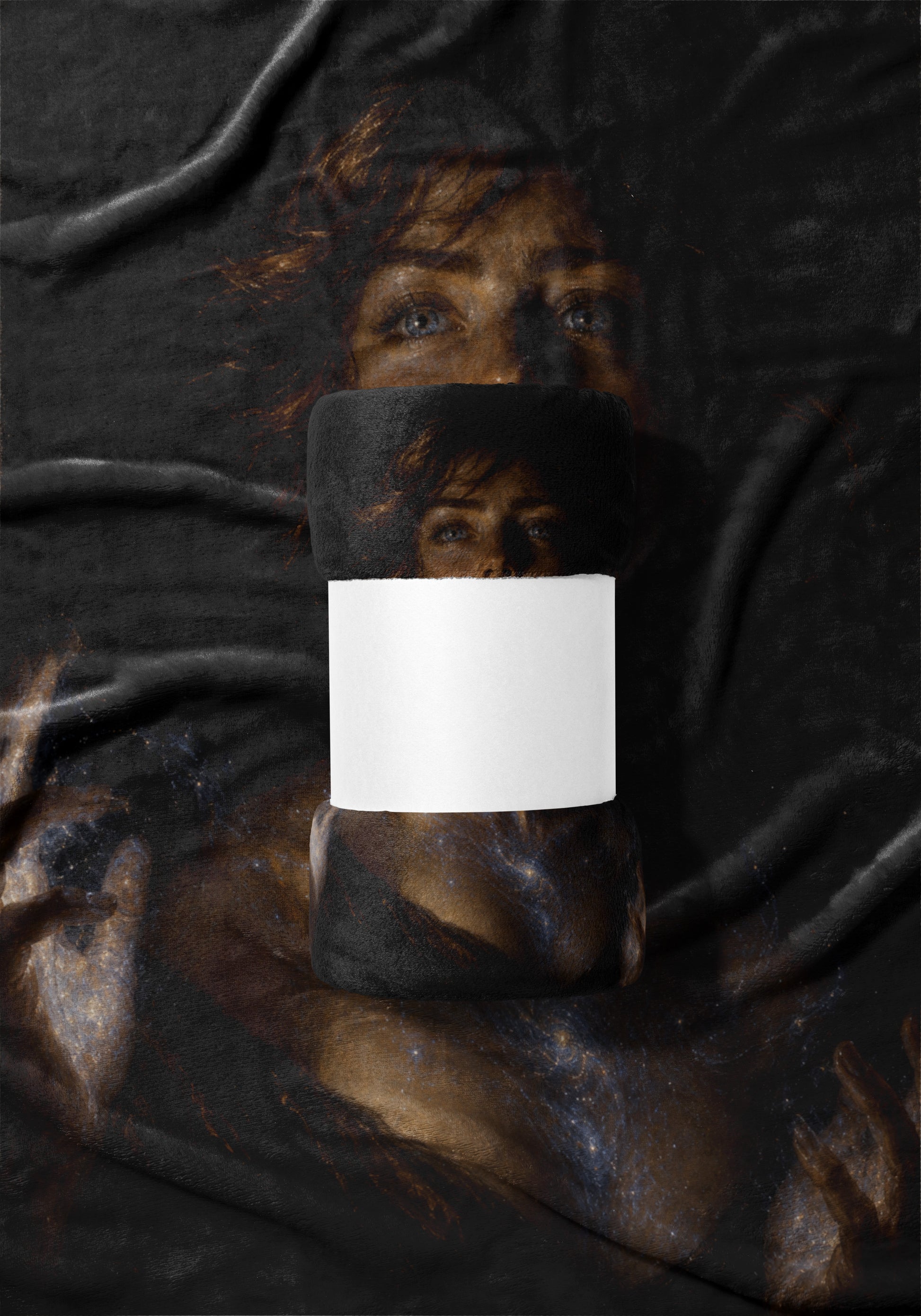 Rolled blanket with a space nebula and painted portrait of a woman's eyes, blank label.