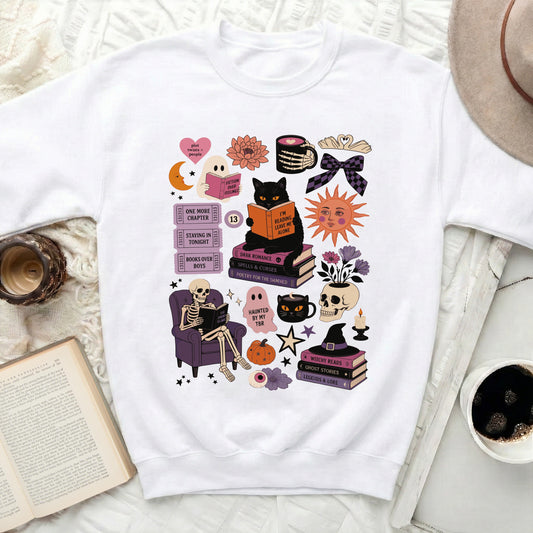 White sweatshirt with Halloween-themed reading graphics including a black cat and skeleton.