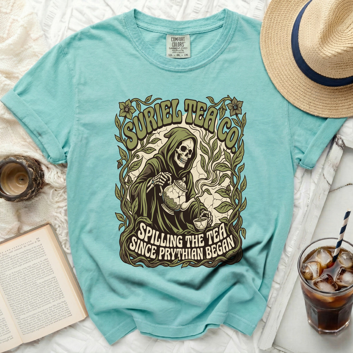 Aqua t-shirt with Grim Reaper pouring tea graphic and text "Spilling the Tea Since Phrythian Began".