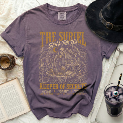 Purple t-shirt with "The Suriel Spill The Tea Keeper of Secrets" gold graphic.