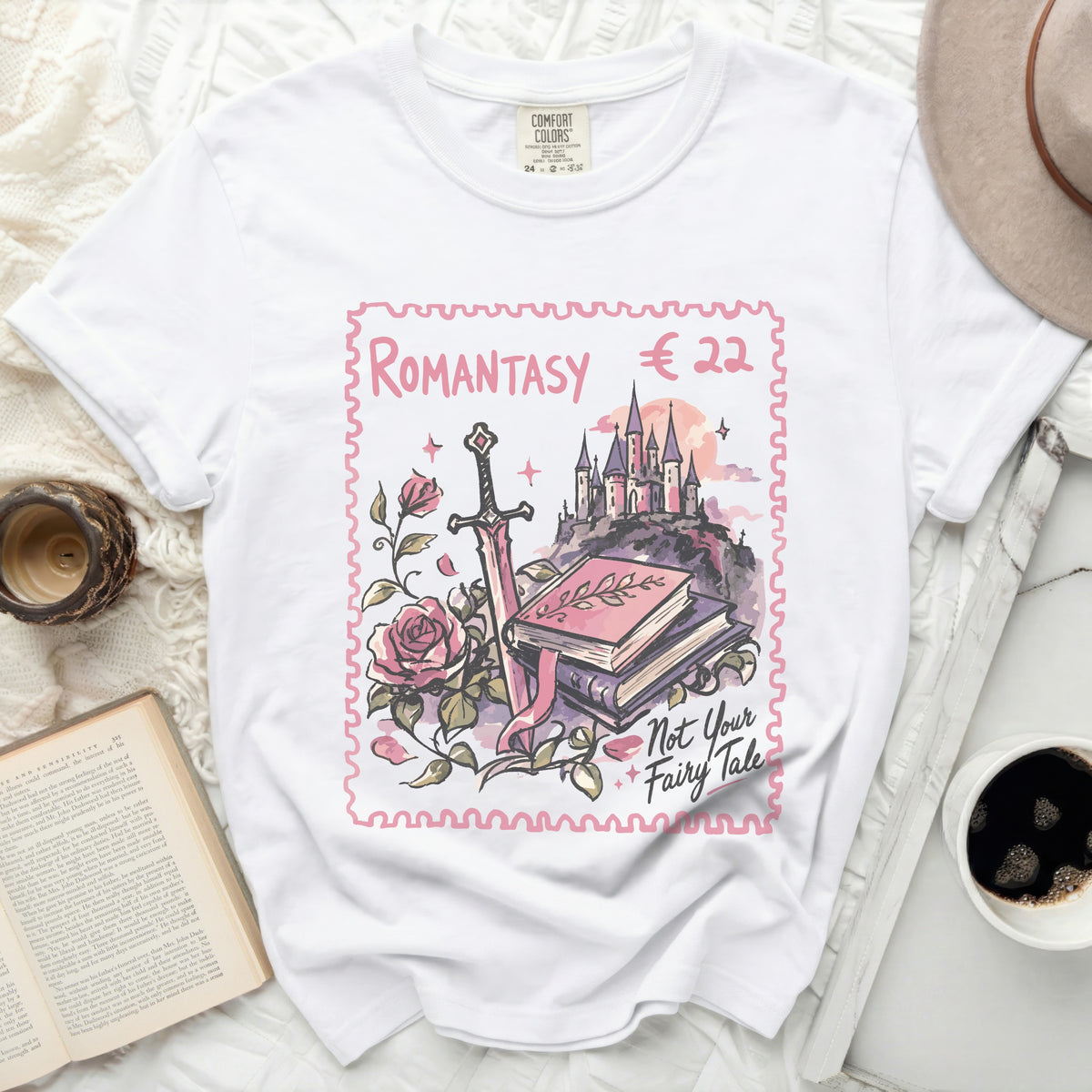 White t-shirt with "ROMANTASY" design featuring sword, books, castle, and roses.