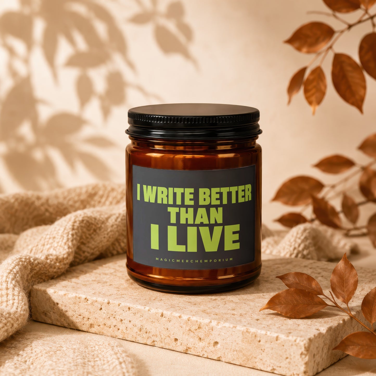 Amber candle with black lid, text reads "I WRITE BETTER THAN I LIVE".