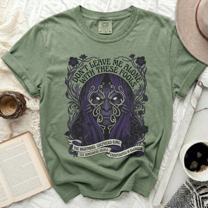 Green t-shirt with purple creature and text "Don't leave me alone with these fools."