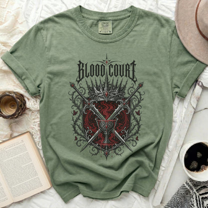 Green t-shirt with "BLOOD COURT" text, crowns, swords, and chalice graphic.