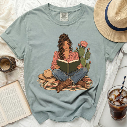 Illustration of a woman reading a book, sitting on a rug with cacti.