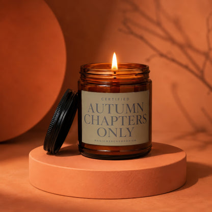Brown glass candle lit, with a label reading "Autumn Chapters Only".