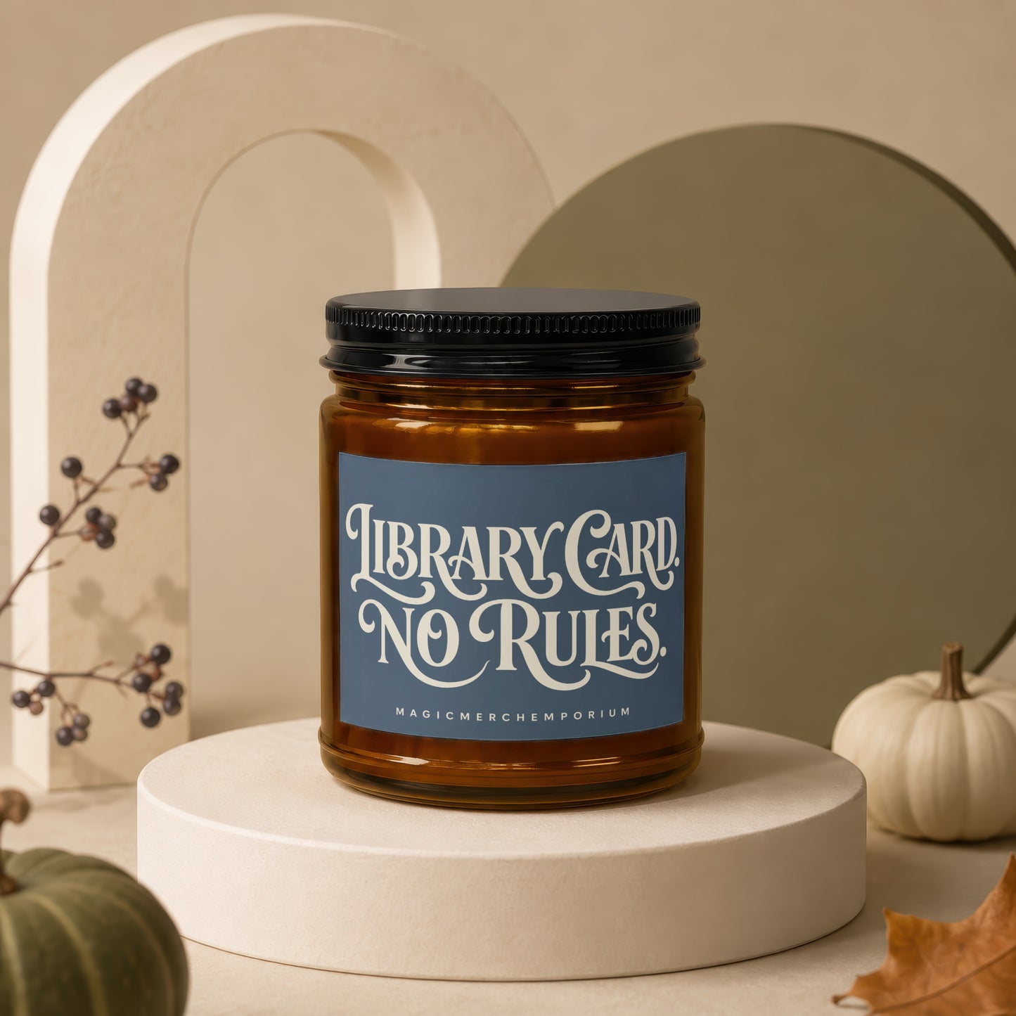 Amber candle with "LIBRARY CARD NO RULES MAGICMERCH)EMPORIUM" label on a podium with pumpkins.