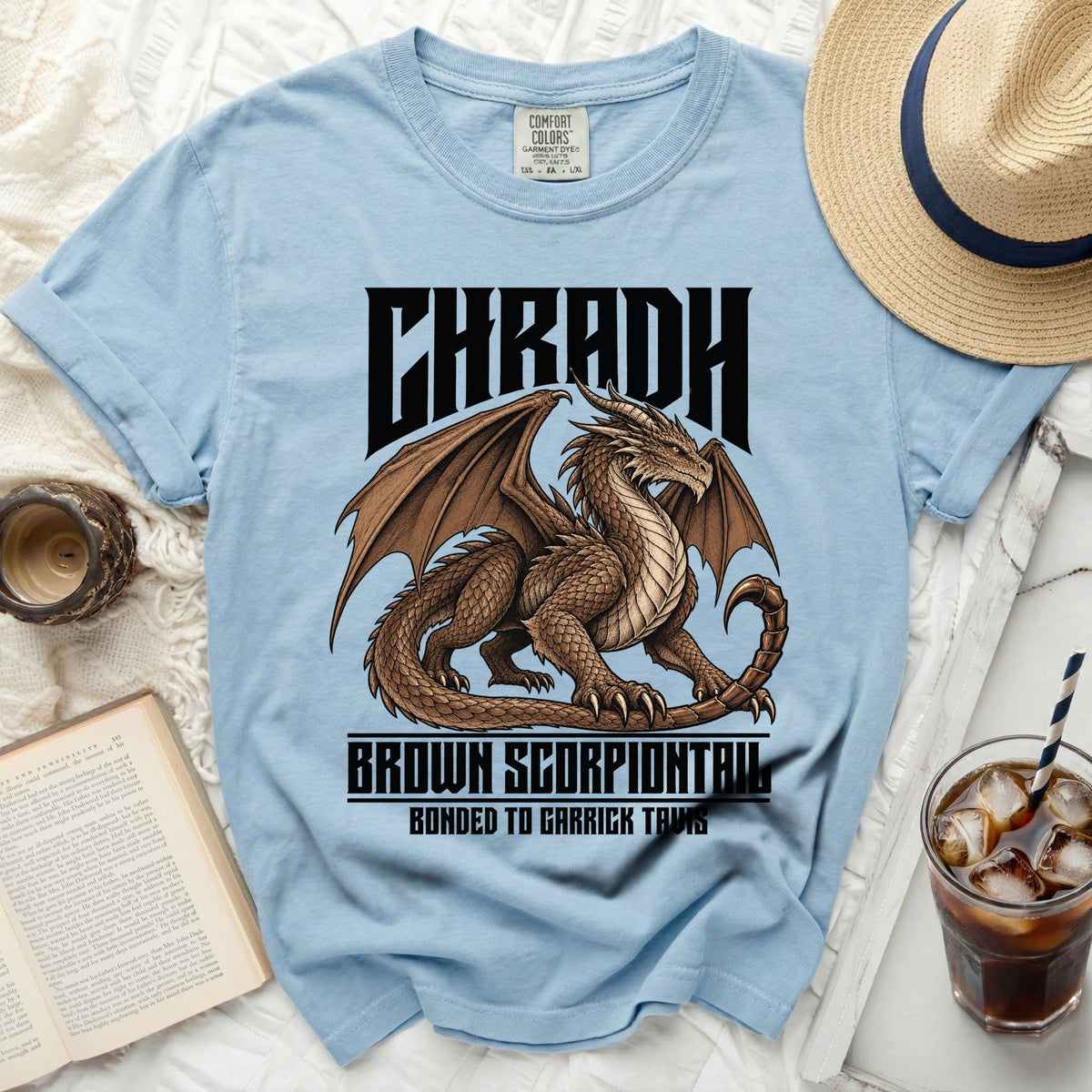 Light blue t-shirt with a brown dragon graphic and text "CHRADH BROWN SCORPIONTRIL".