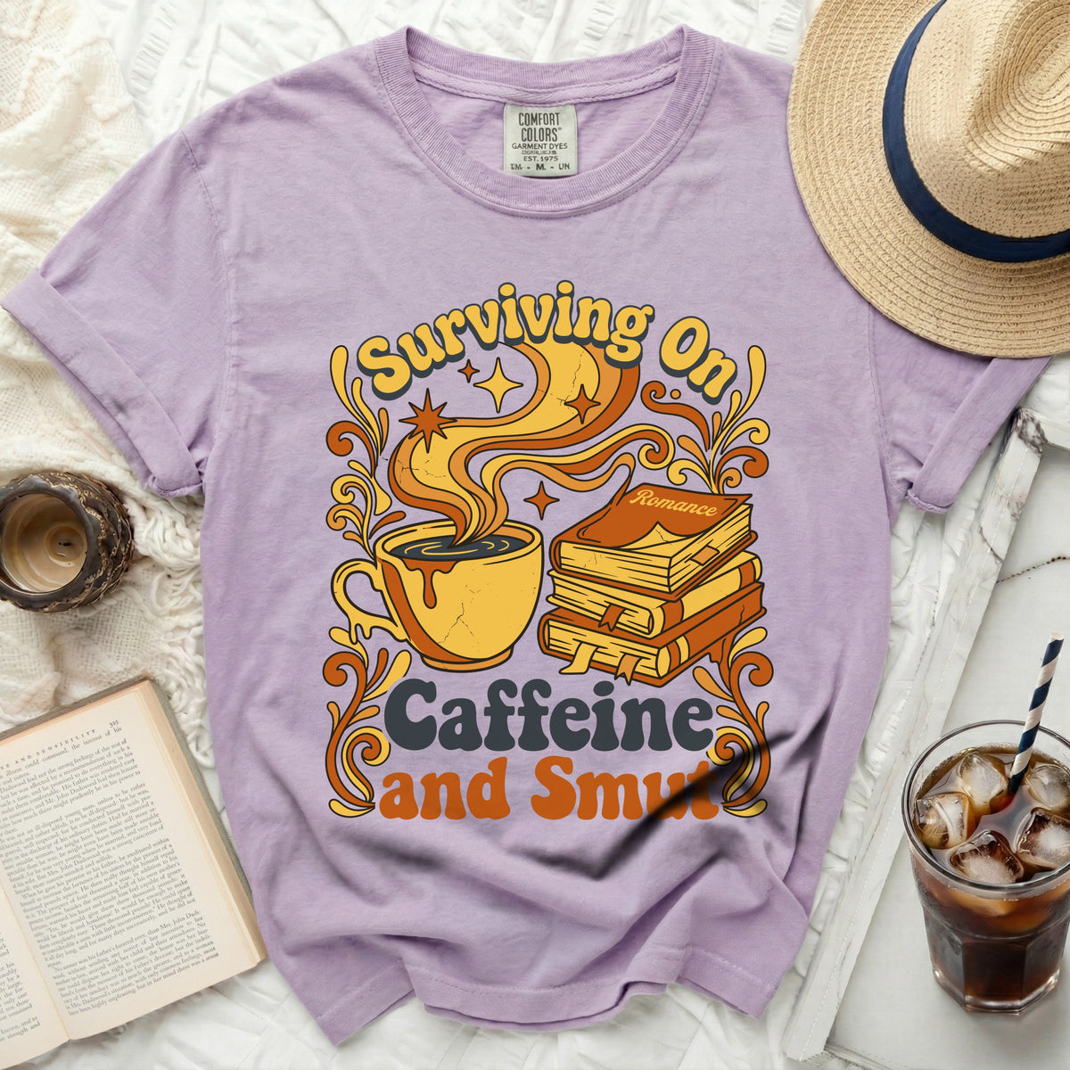 Purple t-shirt with "Surviving On Caffeine and Smut" graphic.