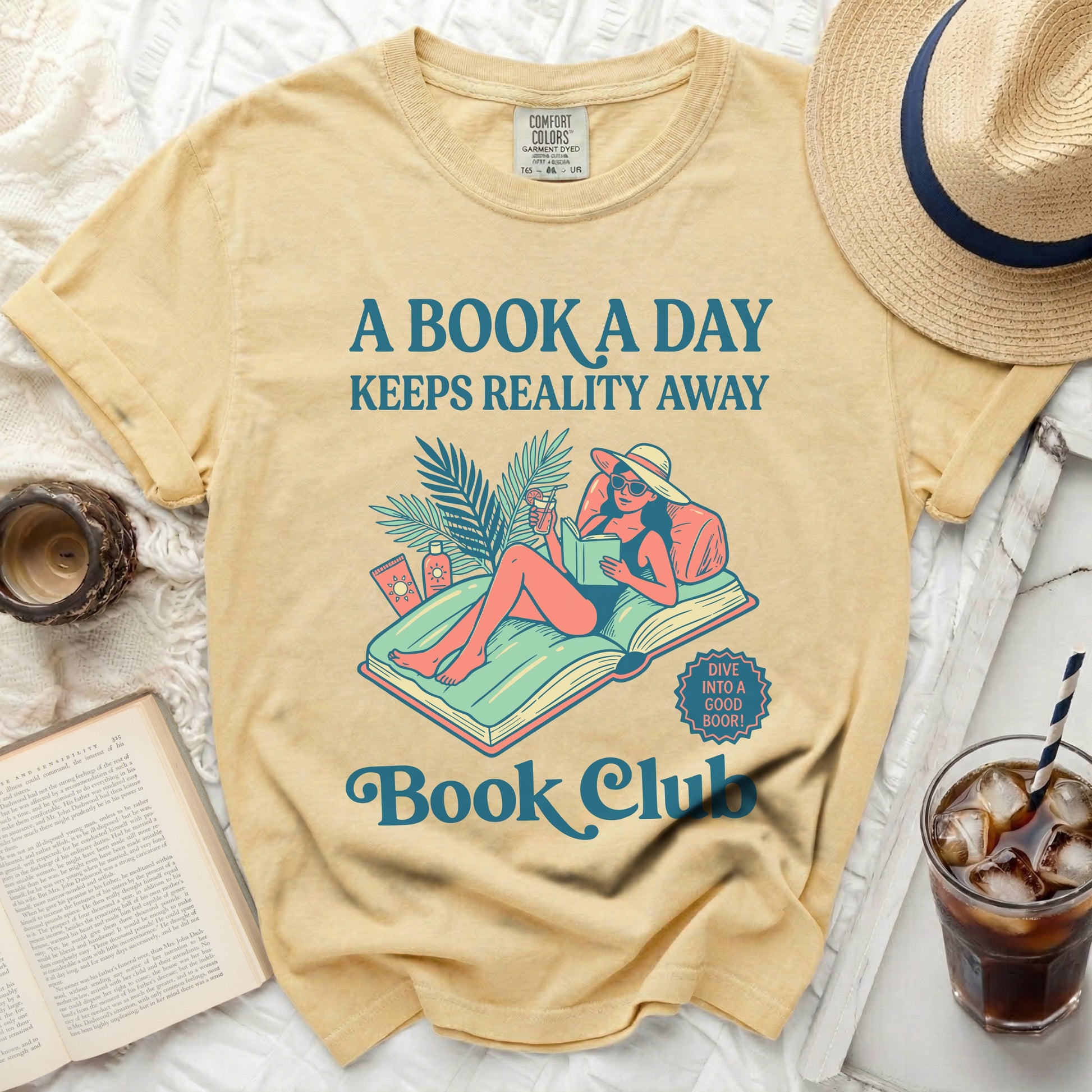 Yellow t-shirt with "A Book a Day" and "Book Club" text, featuring a woman reading by a pool.