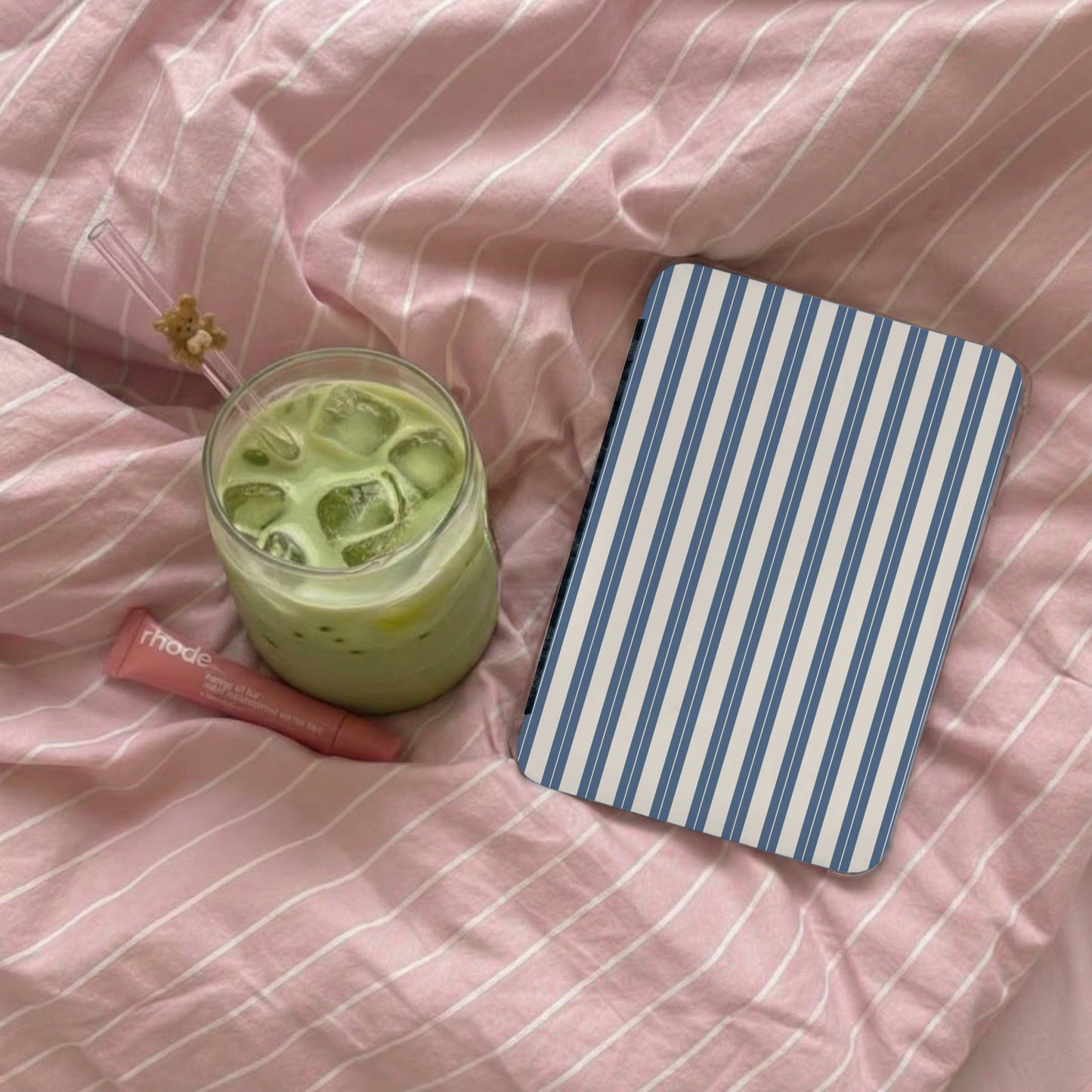 Blue and White Striped Notebook on Cozy Pink Bedding