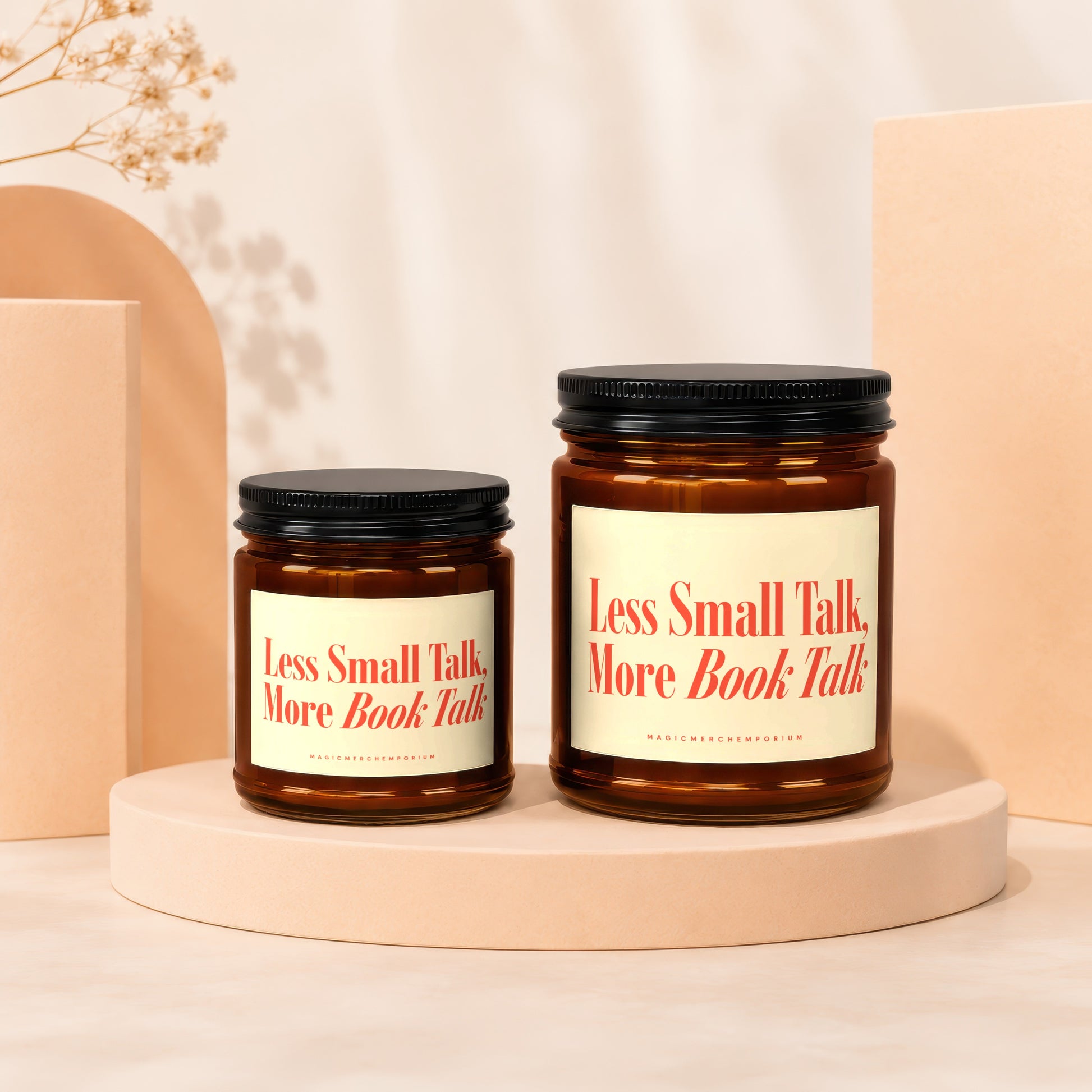 Two amber candles with cream labels featuring red text reading "Less Small Talk. More Book Talk."