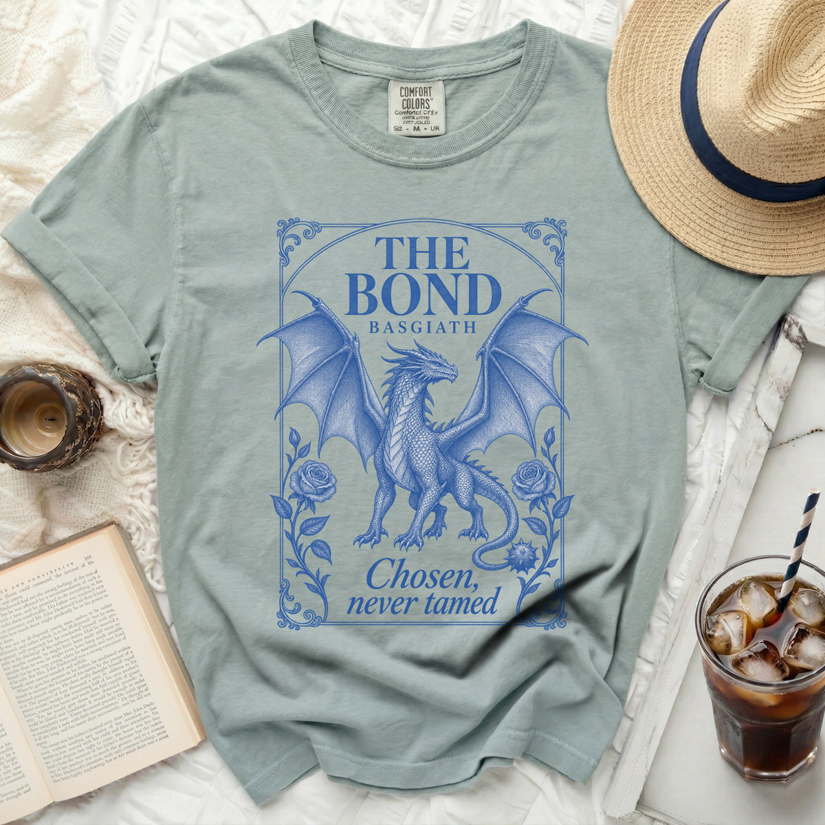A sage green t-shirt features a blue vintage dragon graphic with text reading The Bond Basgiath.