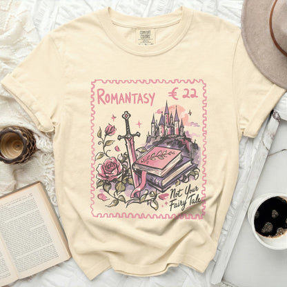 Cream t-shirt with a stamp design of a castle, sword, roses, and books.