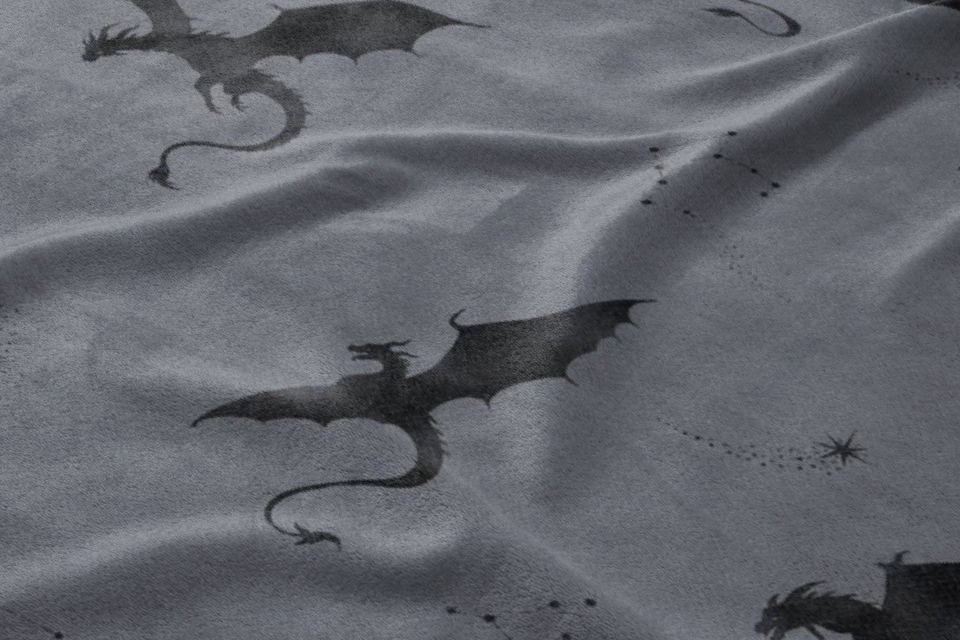 Dark gray fabric with a repeating pattern of silhouetted dragons and star constellations.