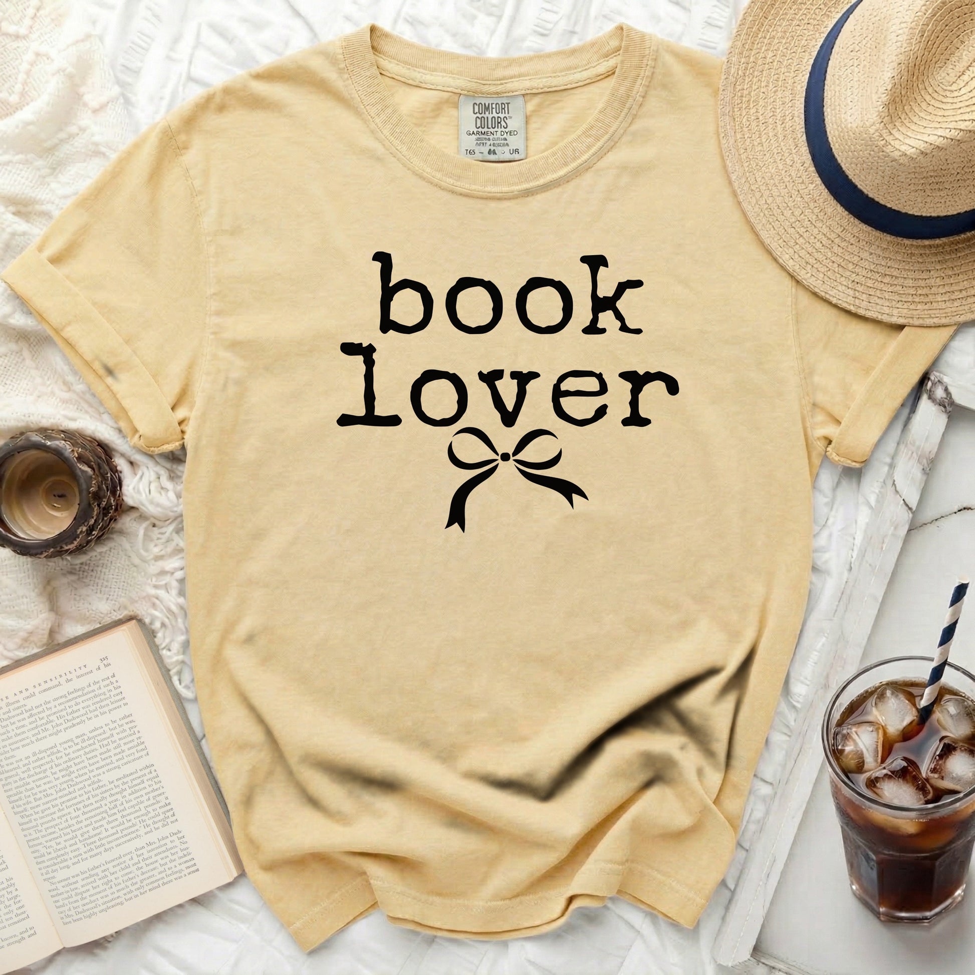 Yellow t-shirt with black "book lover" text and bow graphic.